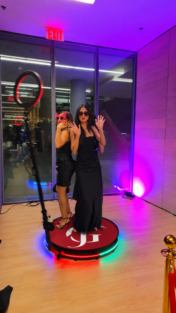 Guests on the 360 photo booth with purple and blue party lighting