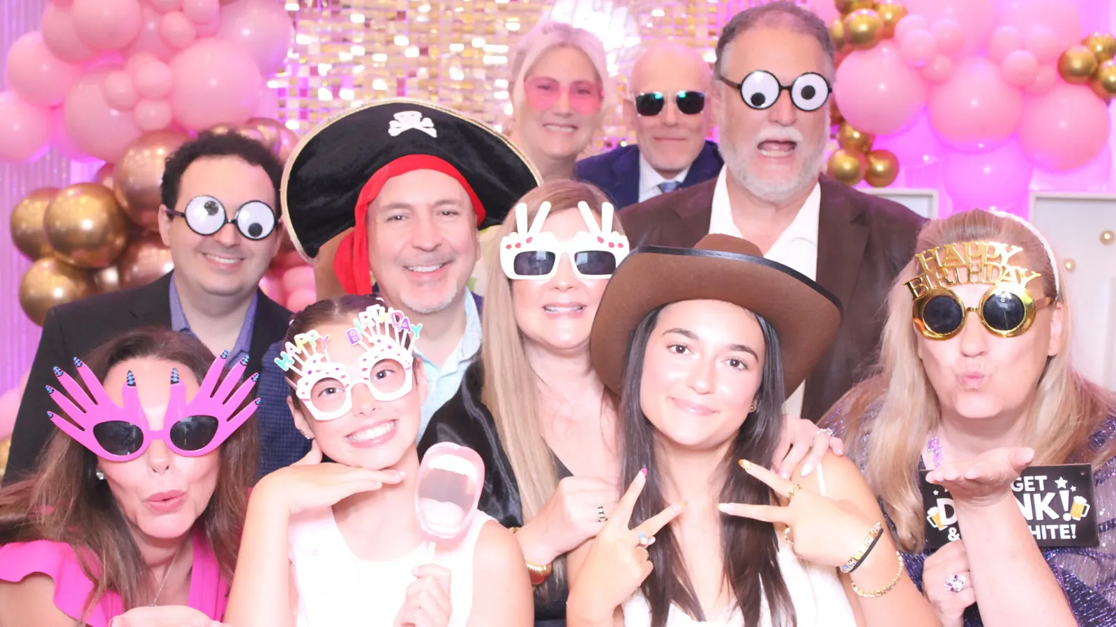 Party guests with props at a photo booth in Markham