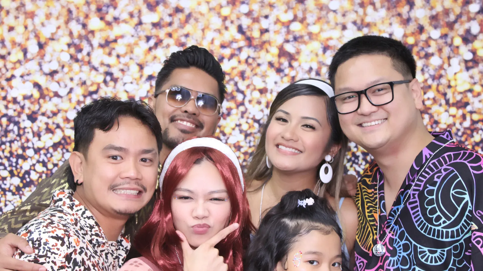 Family group in front of a sequin backdrop at a photo booth in Vaughan