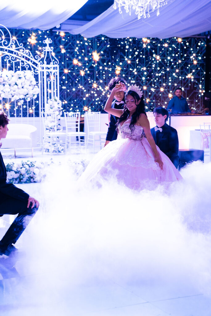 Quinceañera dancing on a cloud of fog under a starry backdrop