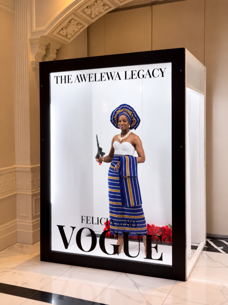 Guest in traditional attire posing in a magazine cover photo booth